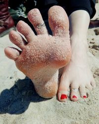 Low section of woman on sand