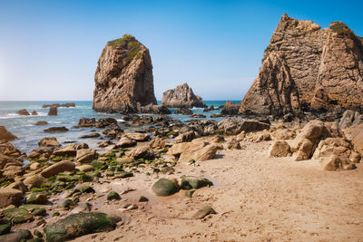 Panoramic view of rocks on beach against clear sky