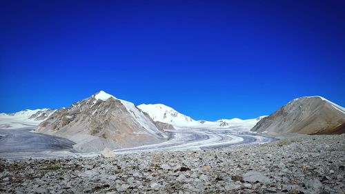 Scenic view of snowcapped mountains against clear blue sky