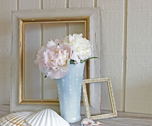 Flower vase and picture frames on table