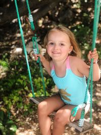 Portrait of a smiling girl holding swing