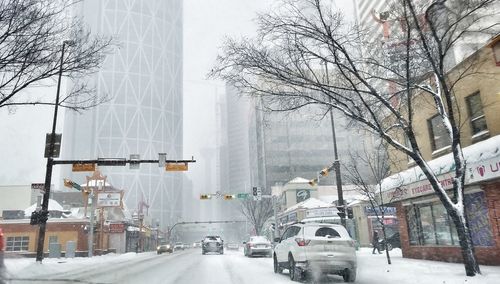 Cars on snow covered road against sky