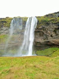 Scenic view of waterfall against sky