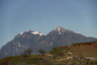 Scenic view of snowcapped mountains against clear blue sky