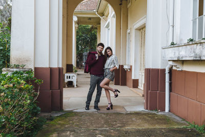 Full length of mother and woman standing in front of building