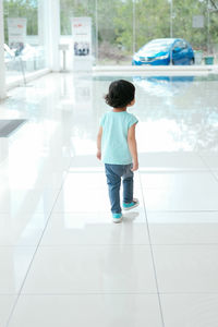 Rear view of boy standing on floor