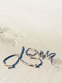 High angle view of text on sand at beach