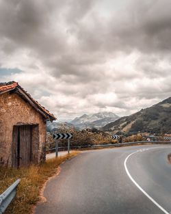 Road leading towards mountain against sky