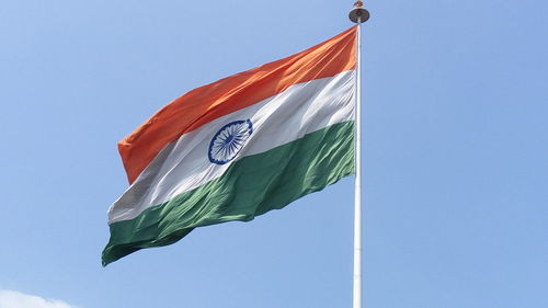 Low angle view of indian flag waving against clear sky