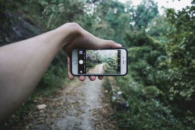 Cropped image of hand holding camera