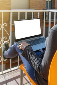 Midsection of man using laptop at home