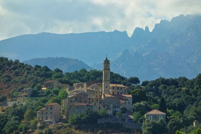 Buildings against sky with mountains in background