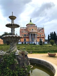 Fountain in front of building against sky