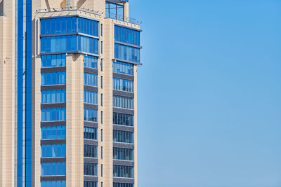 Low angle view of modern building against blue sky