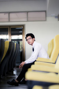 Young man sitting on seat in office