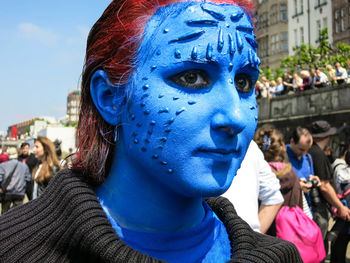 Portrait of woman with face painted blue 