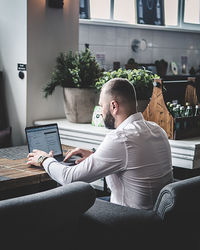 Businessman working on laptop at table in restaurant