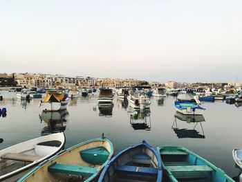 Boats moored in sea against clear sky