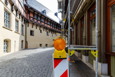 Road sign on street against buildings in city