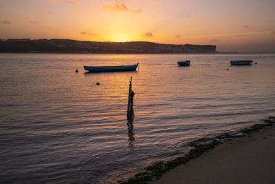 Fishing boats on a river sea at sunset in foz do arelho, portugal