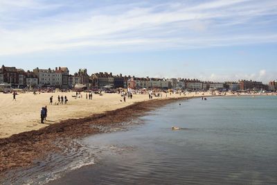 People on beach with city in background