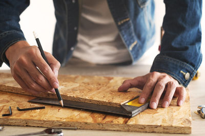 Midsection of man working on table