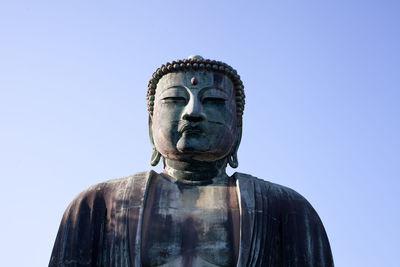 Low angle view of statue against clear blue sky