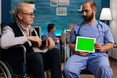 Friends using digital tablet while sitting in cafe