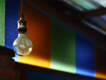 Low angle view of illuminated light bulb on table