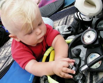 Close-up of boy touching diving equipment while lying on blanket