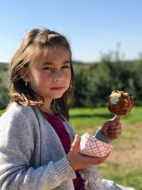 Portrait of girl holding ice cream lollipop at park
