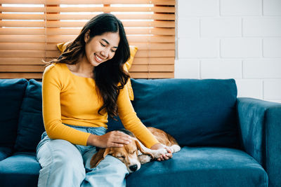 Young woman sitting on sofa at home