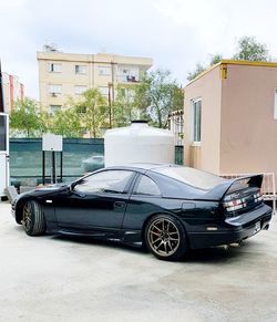 Car parked on street against building in city