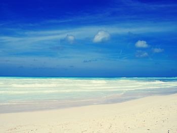 Scenic view of beach against blue sky