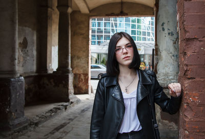 Young woman standing against wall