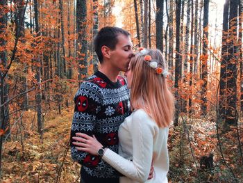 Young couple standing in forest during autumn