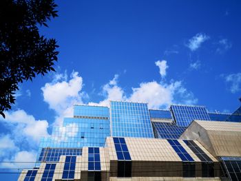 Low angle view of electricity pylon against blue sky