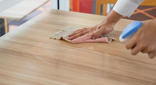 Close-up of hand holding ice cream on table