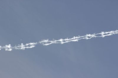 Low angle view of vapor trail against blue sky