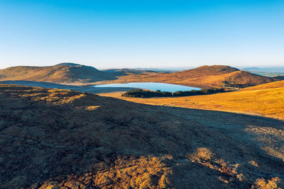 Scenic view of mountains against clear blue sky
