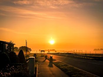 Silhouette road against sky during sunset