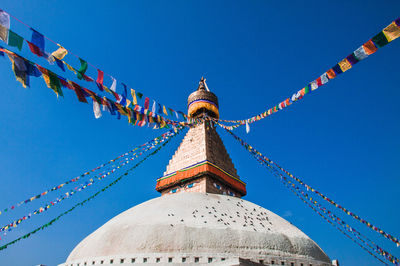 Low angle view of bell tower against blue sky