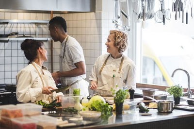 Cheerful multi-ethnic chefs working in kitchen at restaurant