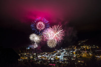 Firework display over cityscape at night