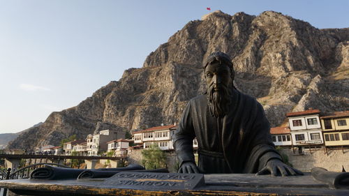 Statue in front of mountain range
