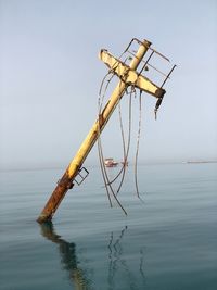 Crane on sea against sky