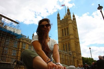 Low angle view of woman sitting against sky