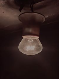 Close-up of illuminated light bulb against black background