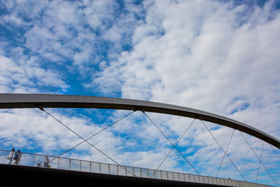 Low angle view of bridge against cloudy sky