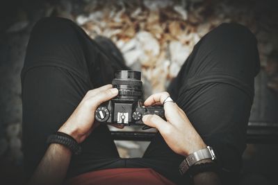 Low section of man holding camera